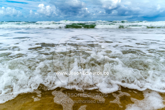 Storm surge waves rolling onto an empty beach. Point Arkwright, Yaroomba Beach, Queensland, Australia.