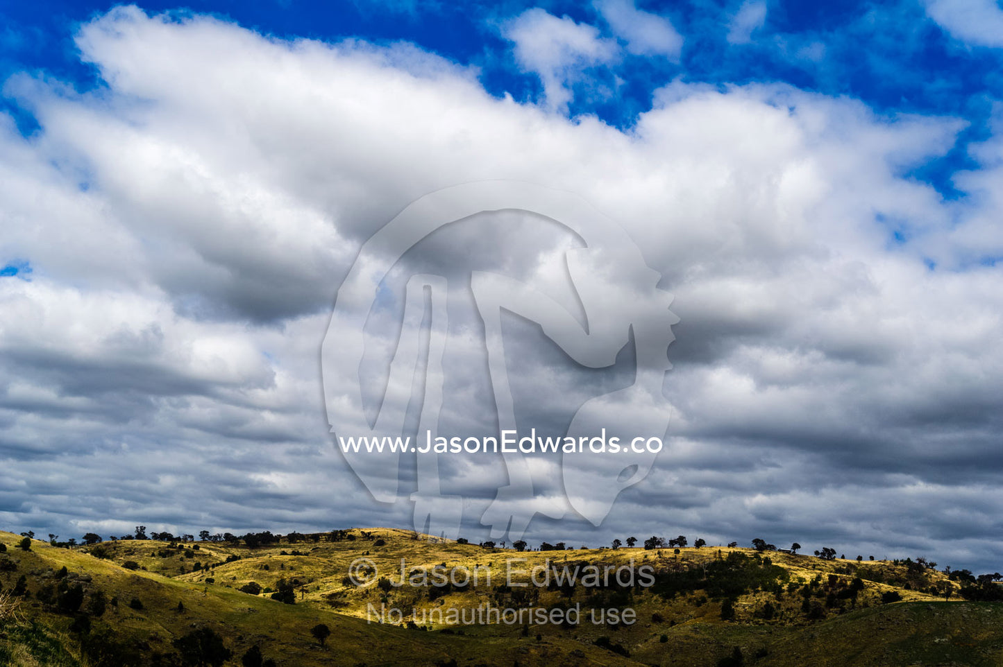 Rain clouds above dry rolling farmland on a summer day. Euroa, Strathbogie, Victoria, Australia.