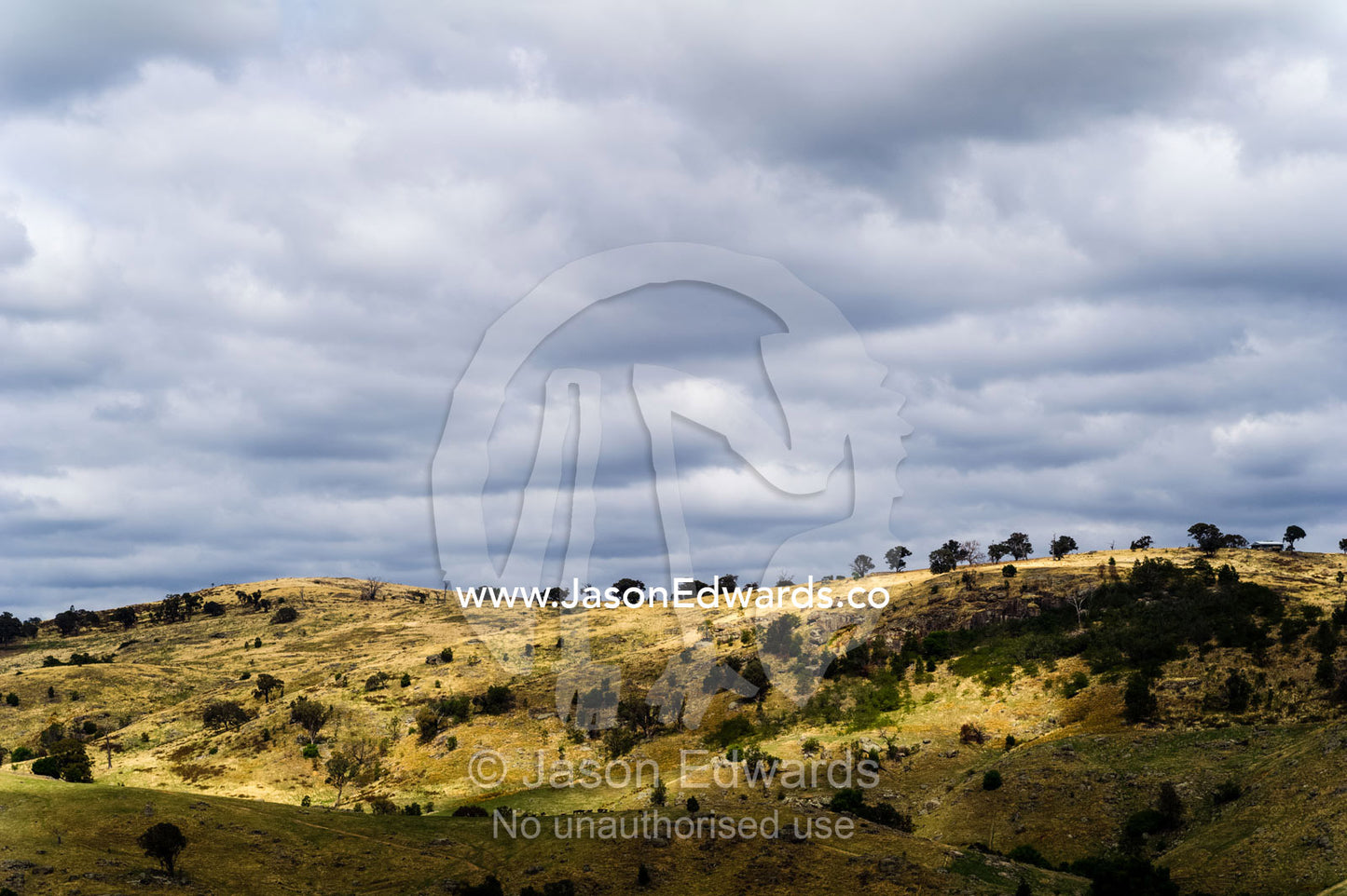 Rain clouds above dry rolling farmland on a summer day. Euroa, Strathbogie, Victoria, Australia.