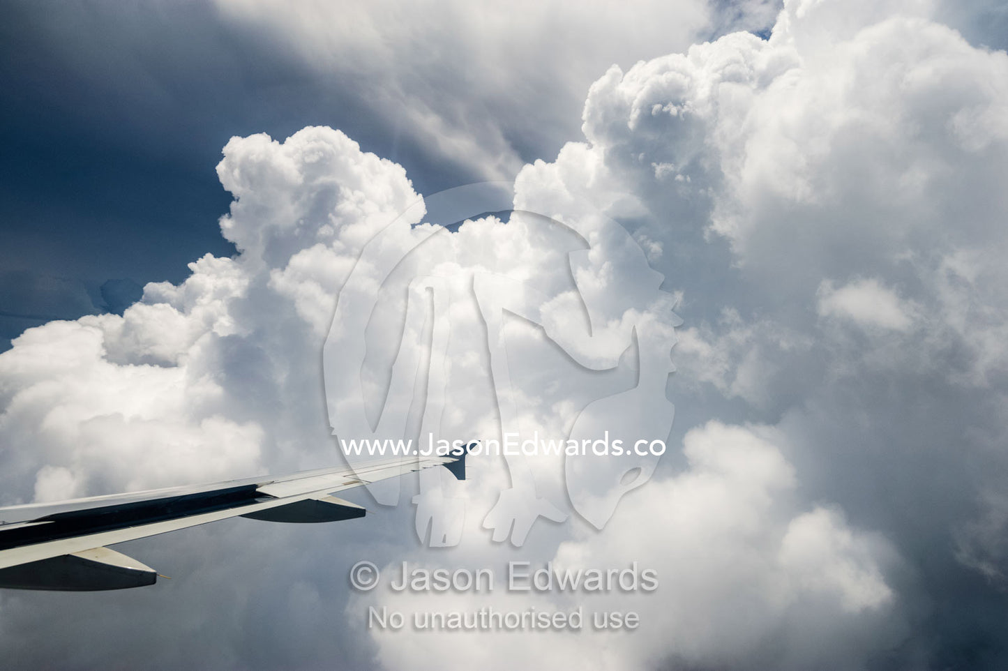 The tip of a wing from a passenger plane flying through a cloud bank. near Victoria Falls, Zambia.