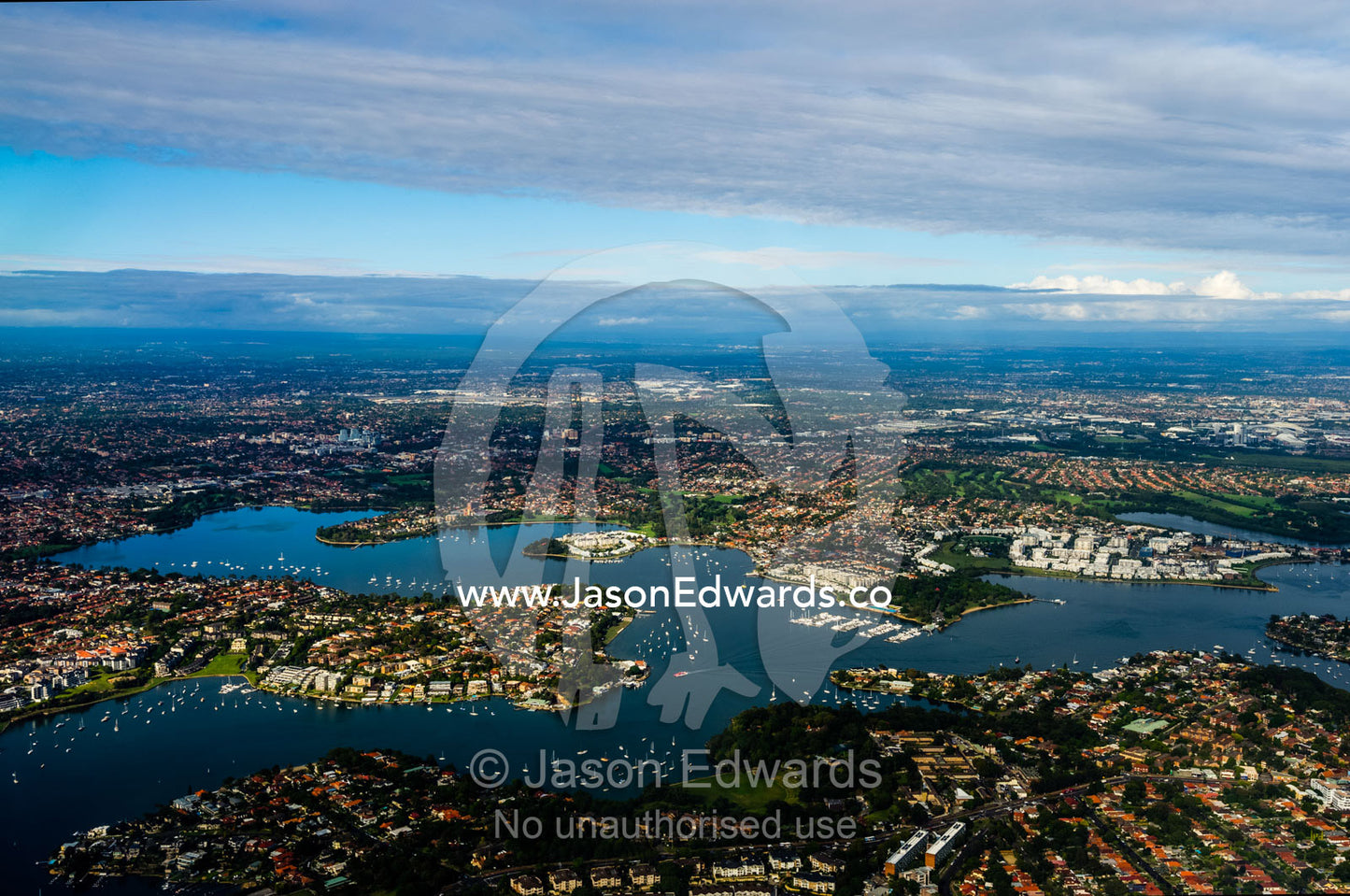 The rooftops of sprawling suburbs surrounding a harbour bay near Sydney. Sydney, New South Wales, Australia.