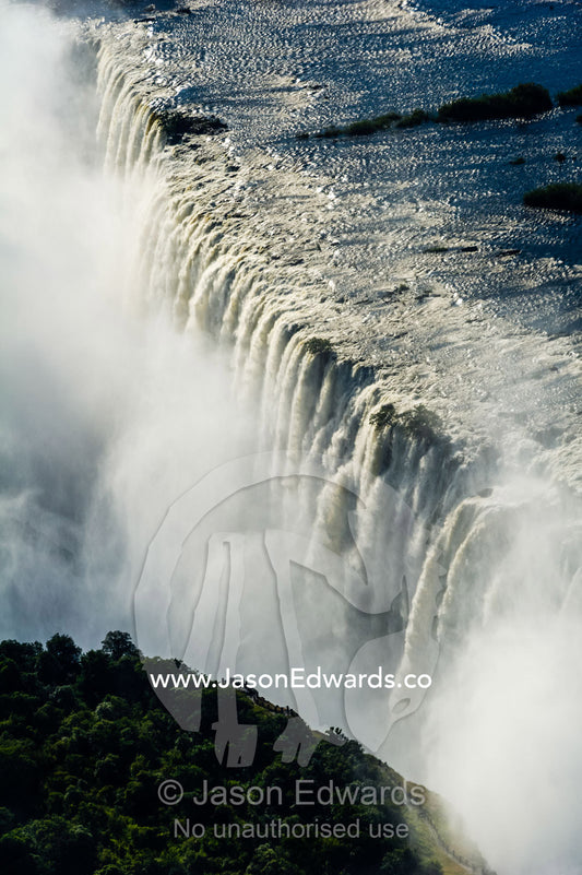 Torrents of water from the Zambezi River cascade over Victoria Falls into the chasm at First Gorge. Zambezi River, Victoria Falls, Mosi-oa-Tunya National Park, Zambia.