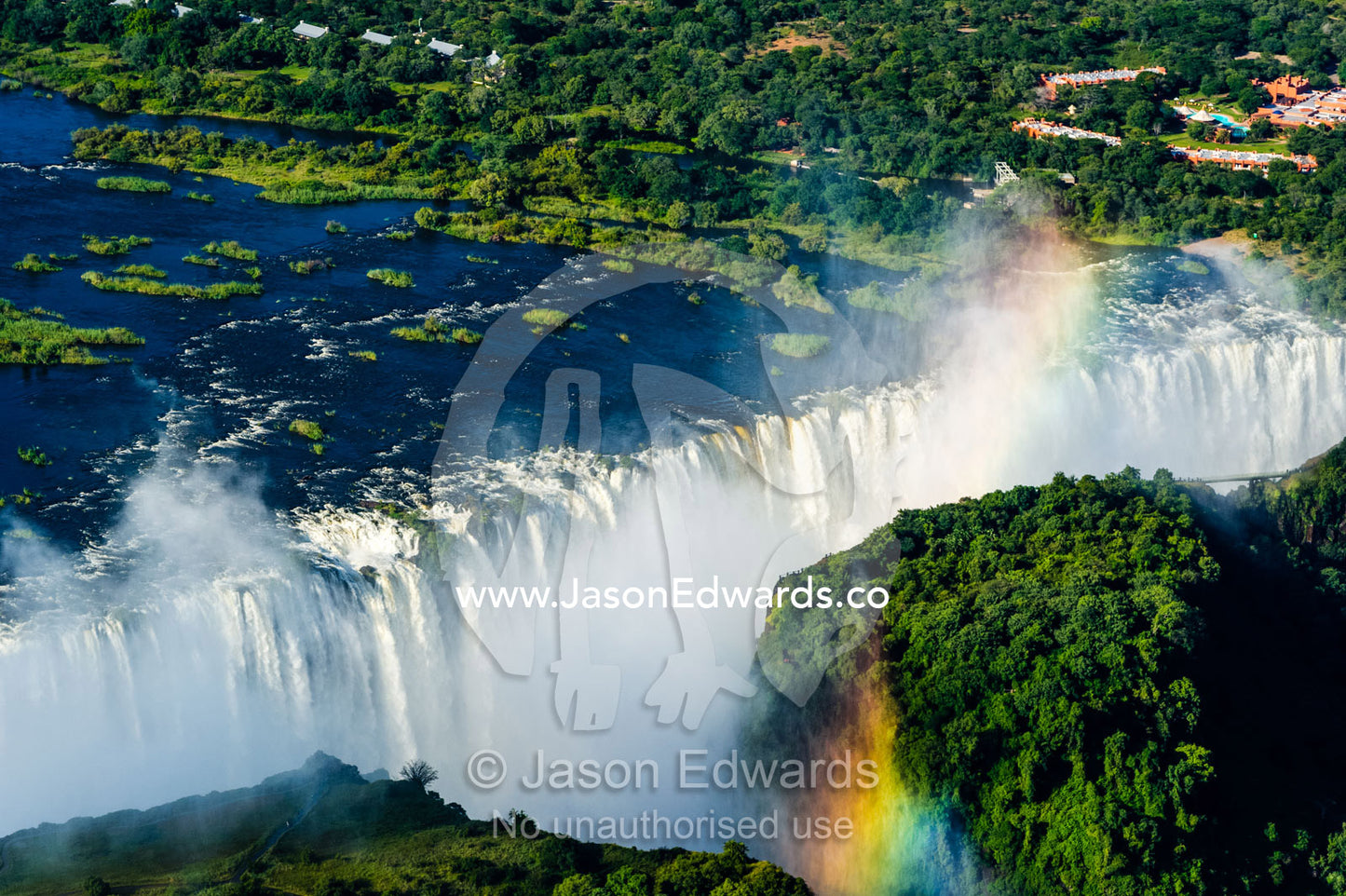 Torrents of water from the Zambezi River cascade over Victoria Falls into a chasm creating a rainbow. Zambezi River, Victoria Falls, Mosi-oa-Tunya National Park, Victoria Falls National Park, Zambia.