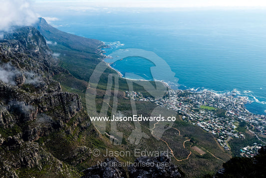 A small coastal community nestled at the base of a mountain range. Table Mountain, Cape Town, Western Cape, South Africa.
