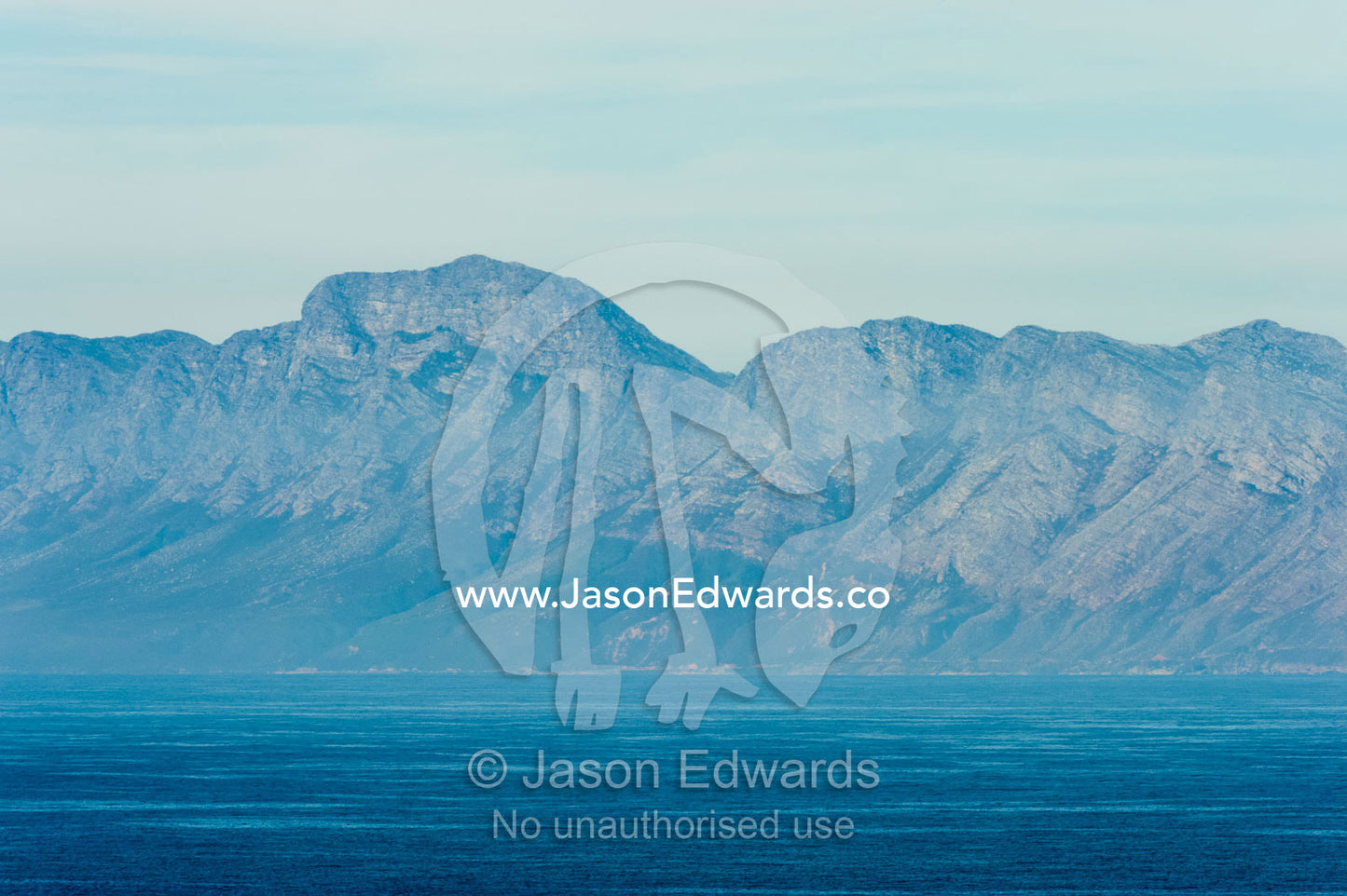 Ocean mist shrouds the shoreline and rugged cliffs of the Cape of Good Hope. Cape of Good Hope, Cape Point, Table Mountain National Park, Cape Peninsula, South Africa.