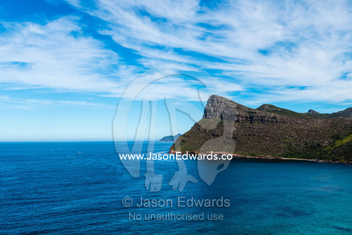 Sheer cliffs and mountain peaks overlooking a blue sea along the Cape of Good Hope. Cape of Good Hope, Cape Point, Table Mountain National Park, Cape Peninsula, South Africa.