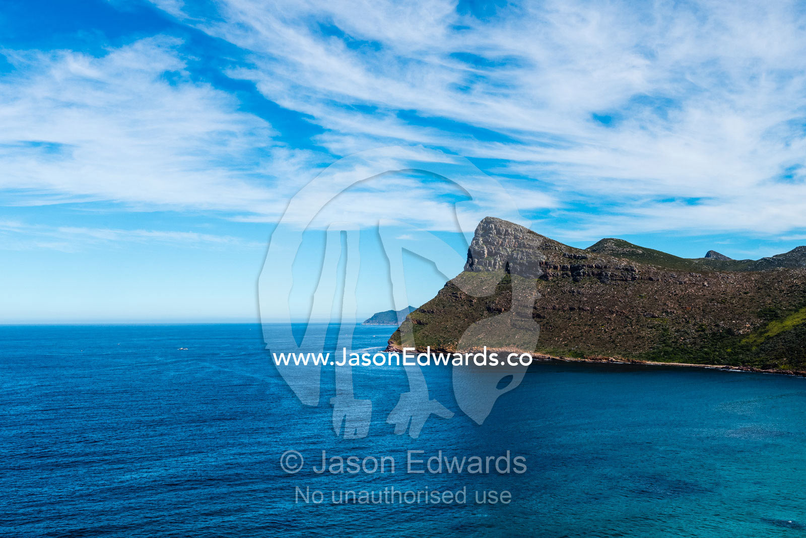 Sheer cliffs and mountain peaks overlooking a blue sea along the Cape of Good Hope. Cape of Good Hope, Cape Point, Table Mountain National Park, Cape Peninsula, South Africa.