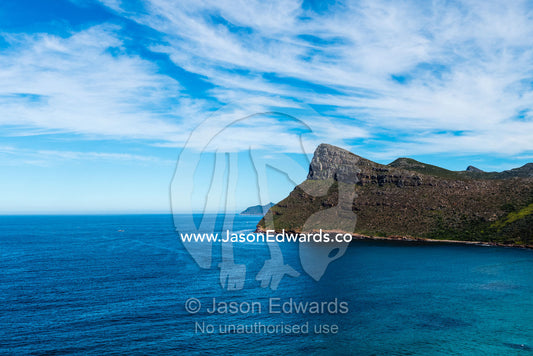 Sheer cliffs and mountain peaks overlooking a blue sea along the Cape of Good Hope. Cape of Good Hope, Cape Point, Table Mountain National Park, Cape Peninsula, South Africa.