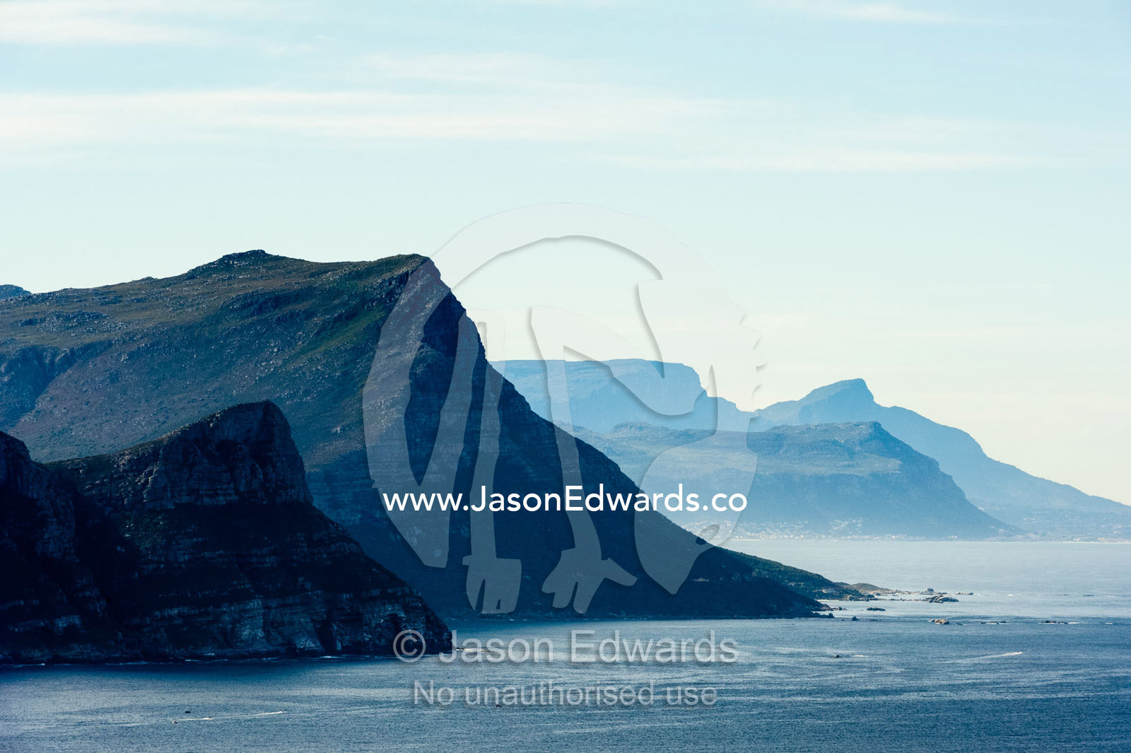 Sheer cliffs and mountain peaks overlooking a blue sea along the Cape of Good Hope. Cape of Good Hope, Cape Point, Table Mountain National Park, Cape Peninsula, South Africa.