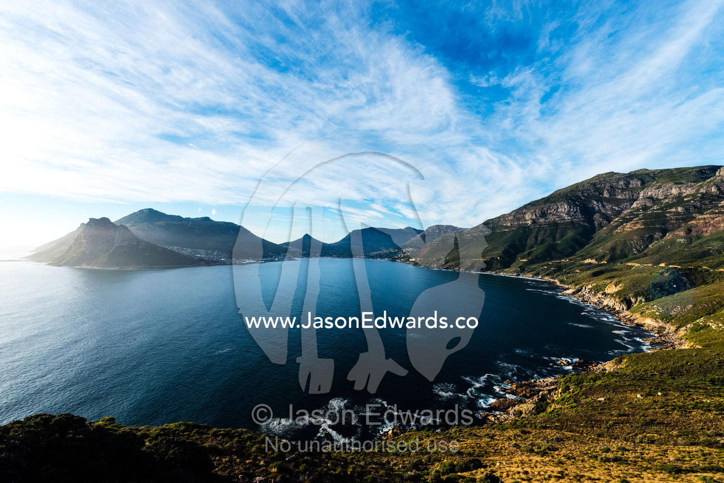 Picturesque and rugged mountains surrounding a bay on South Africa's coastline. Chapmans Peak Drive, Chapmans Peak Mountain Range, Cape Town, Western Cape, South Africa.