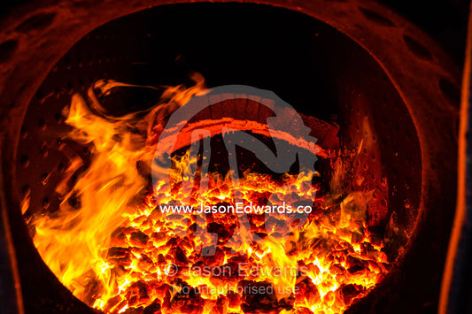 Glowing coals and fire inside the boiler of an antique steam train locomotive. Livingstone, Zambia.