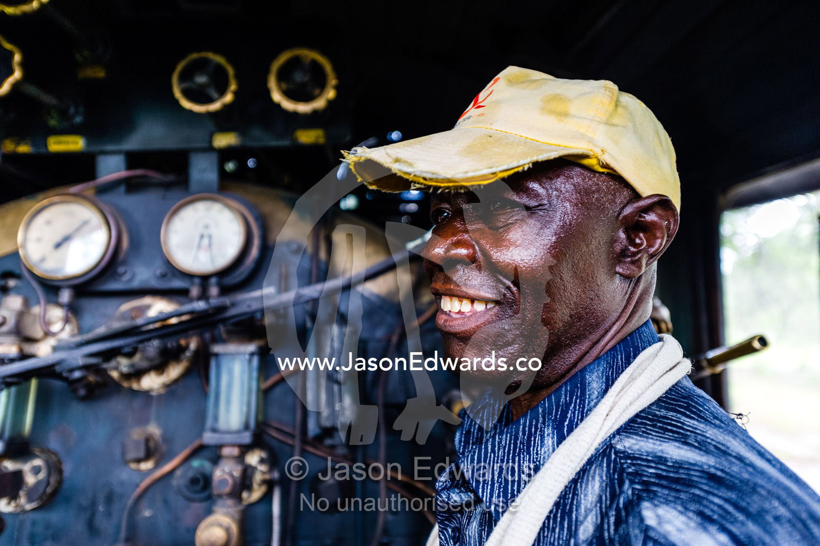 An antique steam train engine driver in the cab of the locomotive. Livingstone, Zambia.
