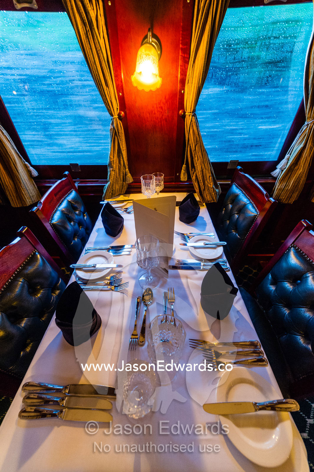 The First Class dining car of an antique steam train replete with silver service. Livingstone, Zambia.
