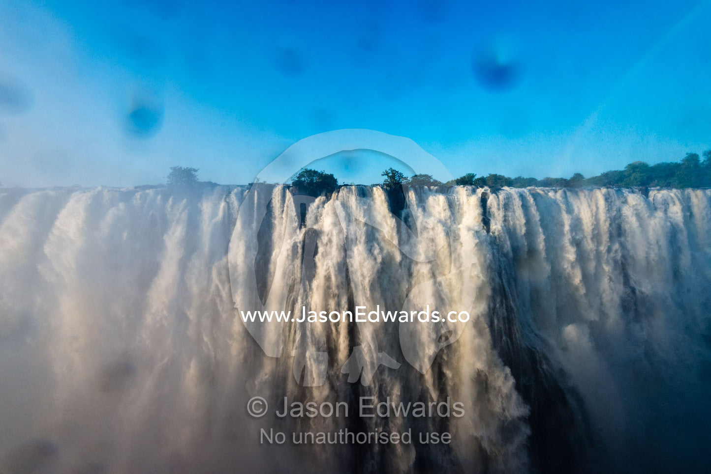 The view of Victoria Falls through a lens covered in water droplets. Zambezi River, Victoria Falls, Mosi-oa-Tunya National Park, Zambia.