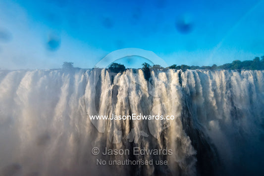 The view of Victoria Falls through a lens covered in water droplets. Zambezi River, Victoria Falls, Mosi-oa-Tunya National Park, Zambia.