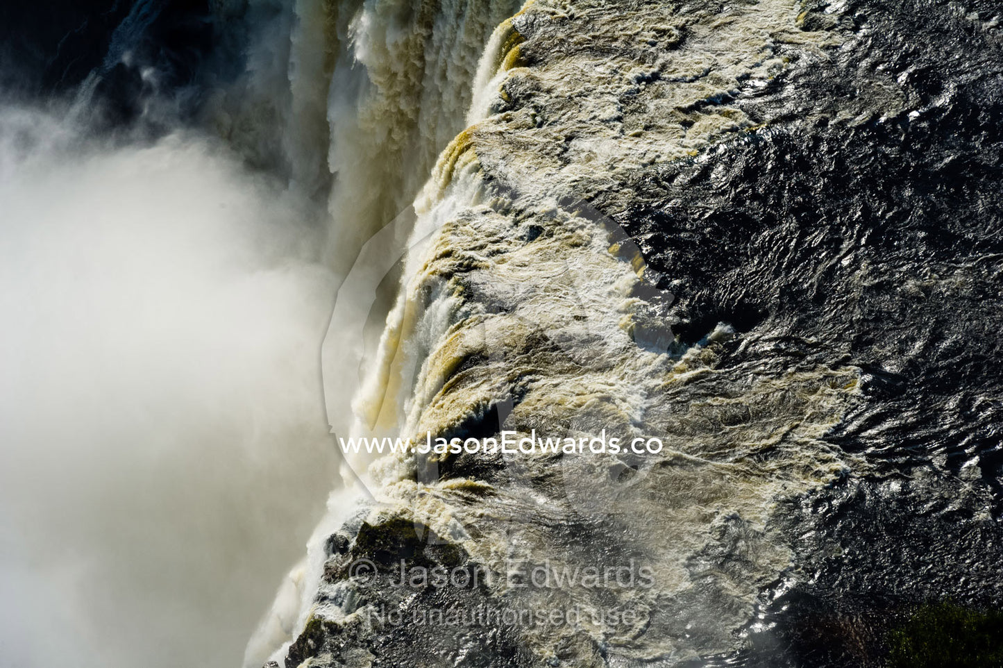 The flooded waters of the Zambezi River pour over Victoria Falls and into the cataract of First Gorge. Zambezi River, Victoria Falls, Mosi-oa-Tunya National Park, Zambia.
