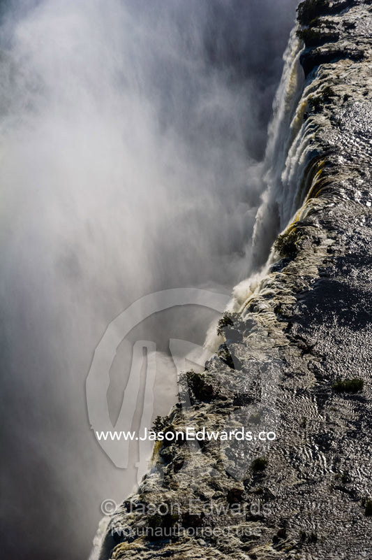 The flooded waters of the Zambezi River pour over Victoria Falls and into the cataract of First Gorge. Zambezi River, Victoria Falls, Mosi-oa-Tunya National Park, Zambia.