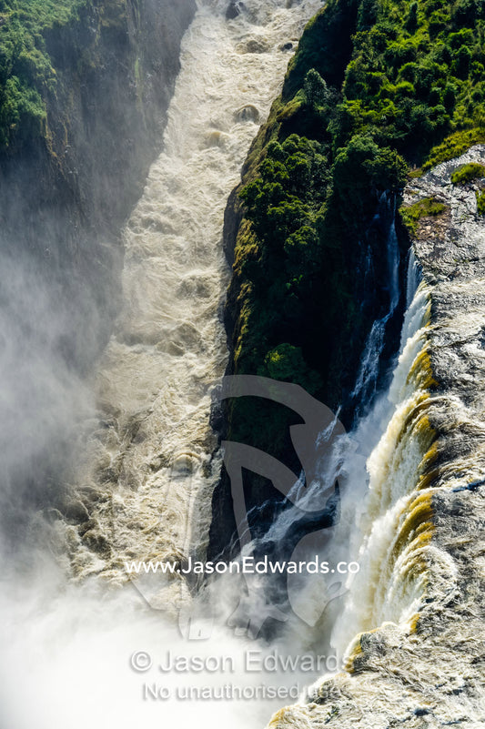 The flooded waters of the Zambezi River pour over Victoria Falls and into the cataract of First Gorge. Zambezi River, Victoria Falls, Mosi-oa-Tunya National Park, Zambia.