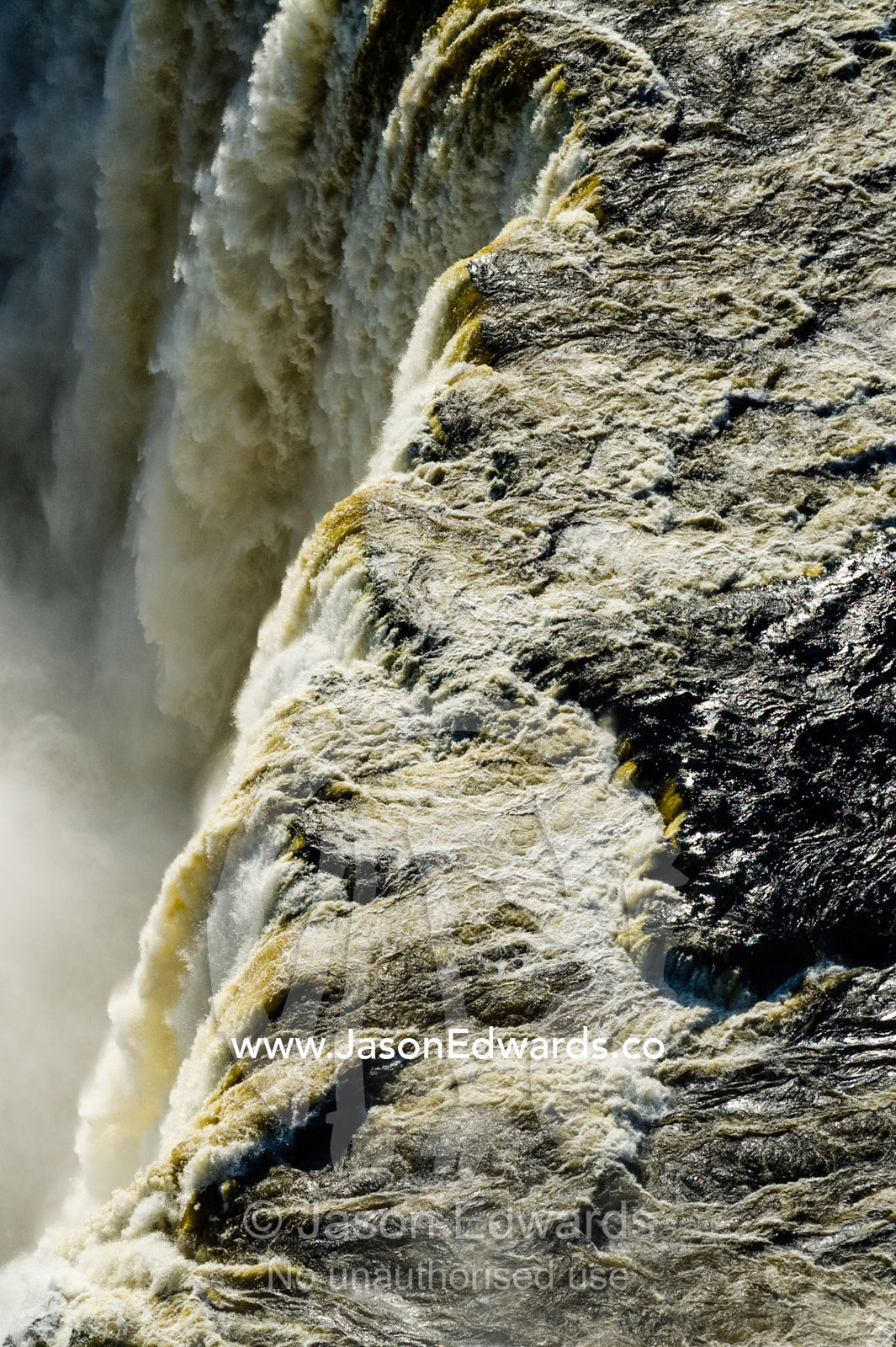 The flooded waters of the Zambezi River pour over Victoria Falls and into the cataract of First Gorge. Zambezi River, Victoria Falls, Mosi-oa-Tunya National Park, Zambia.