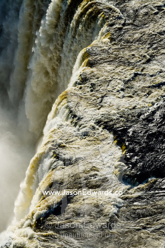 The flooded waters of the Zambezi River pour over Victoria Falls and into the cataract of First Gorge. Zambezi River, Victoria Falls, Mosi-oa-Tunya National Park, Zambia.