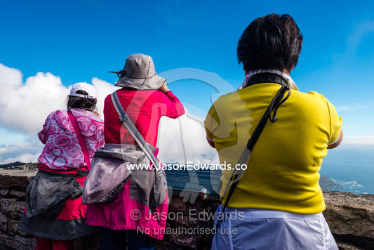 Asian tourists photographing Cape Town from the summit of Table Mountain. Table Mountain, Cape Town, Western Cape, South Africa.