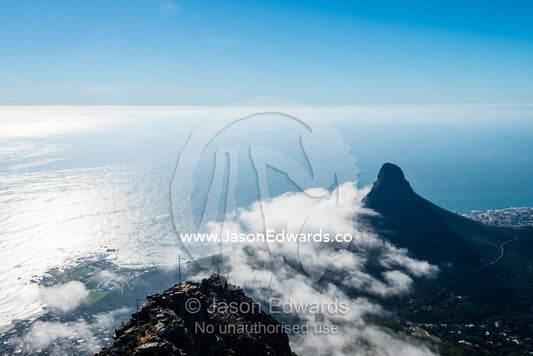 A cloud bank roles in from Table Bay around the base of the Lion's Head. Lion's Head, Table Mountain, Table Bay, Cape Town, Western Cape, South Africa.
