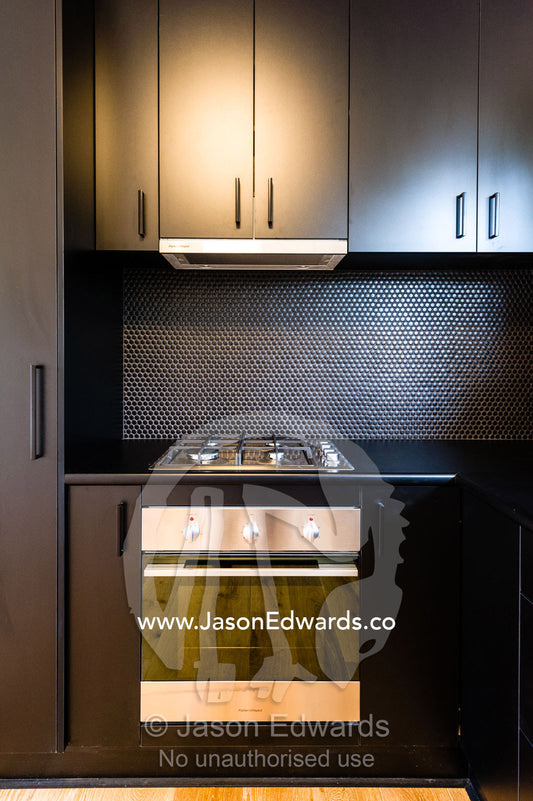 A black modern oven and range cooker in a kitchen in an inner city apartment. Brunswick, Melbourne, Victoria, Australia.