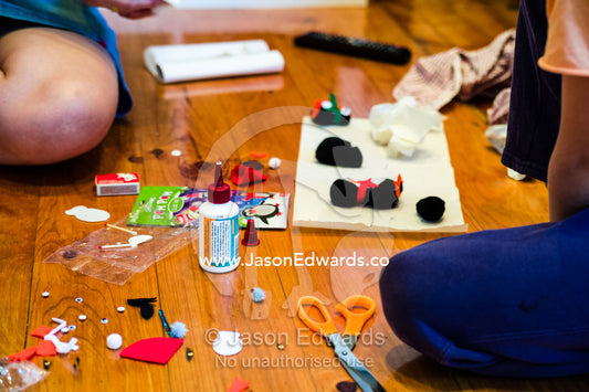 A mother and son make decorations for a Christmas tree. Carlton North, Melbourne, Victoria, Australia.