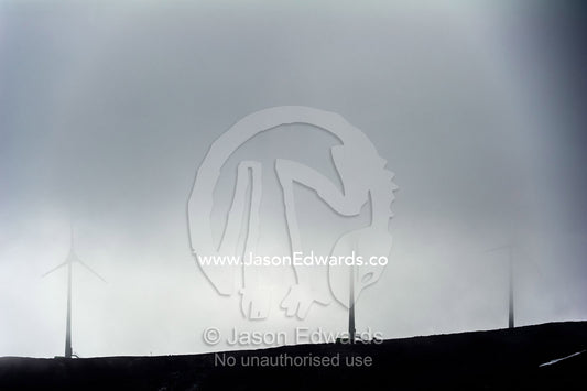 Wind turbines on a barren volcanic hill shrouded in cloud in Antarctica. Crater Hill, Scott Base, Pram Point, Ross Island, Antarctica