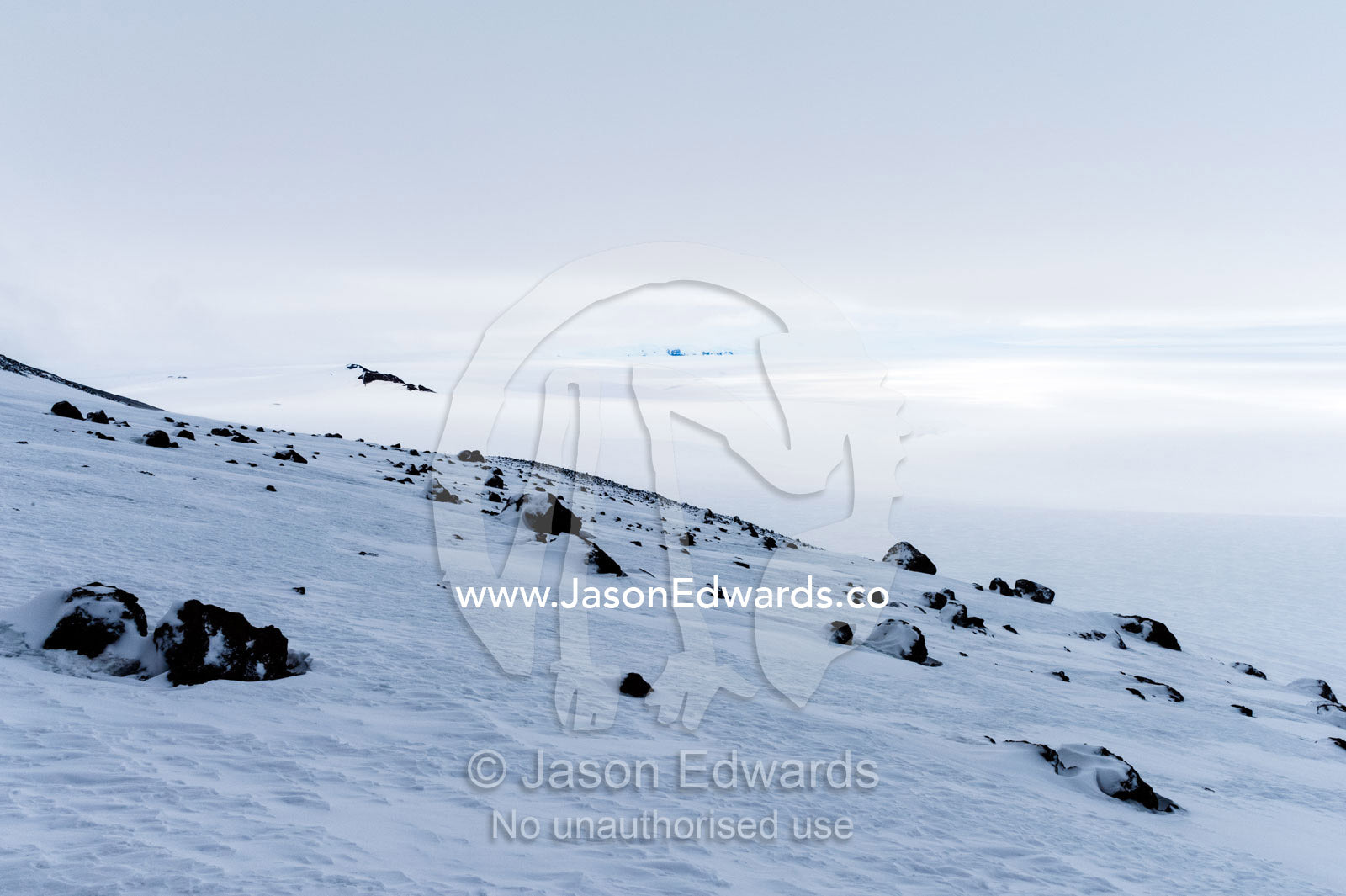 Boulders covered in snow on the slopes of a mountain in Antarctica. Castle Rock, Ross Island, Antarctica