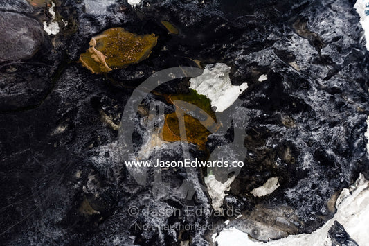 An aerial view of a barren lunar landscape surrounded by ice. Cape Evans, Ross Island, Antarctica