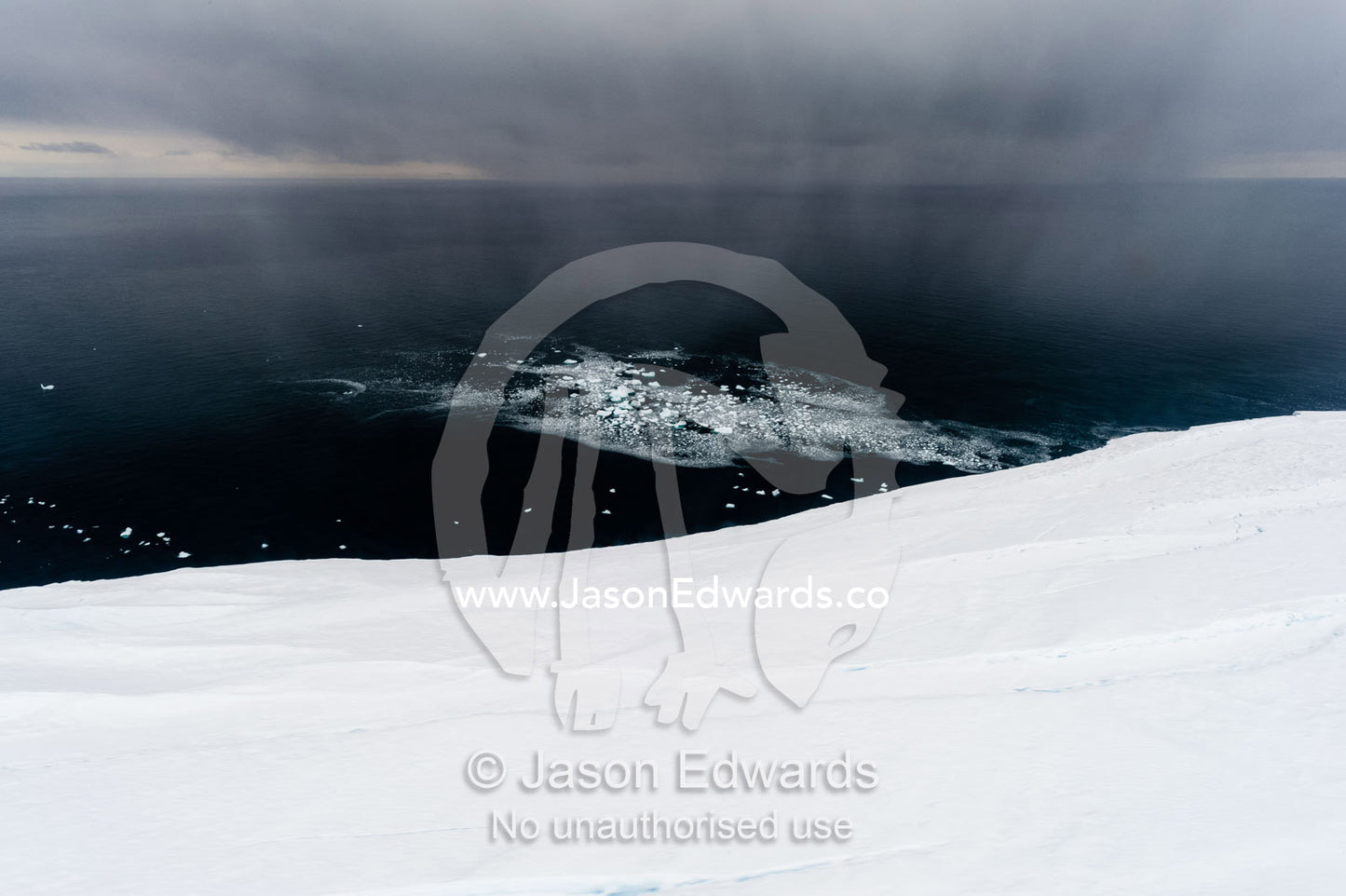 A curtain of snow descends over a glacier tongue in Antarctica. Wohlschlag Bay, Ross Island, Antarctica.