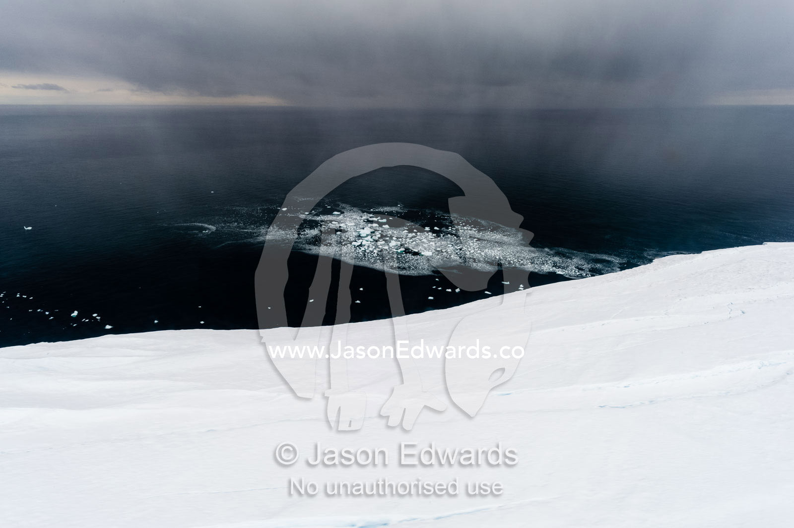 A curtain of snow descends over a glacier tongue in Antarctica. Wohlschlag Bay, Ross Island, Antarctica.
