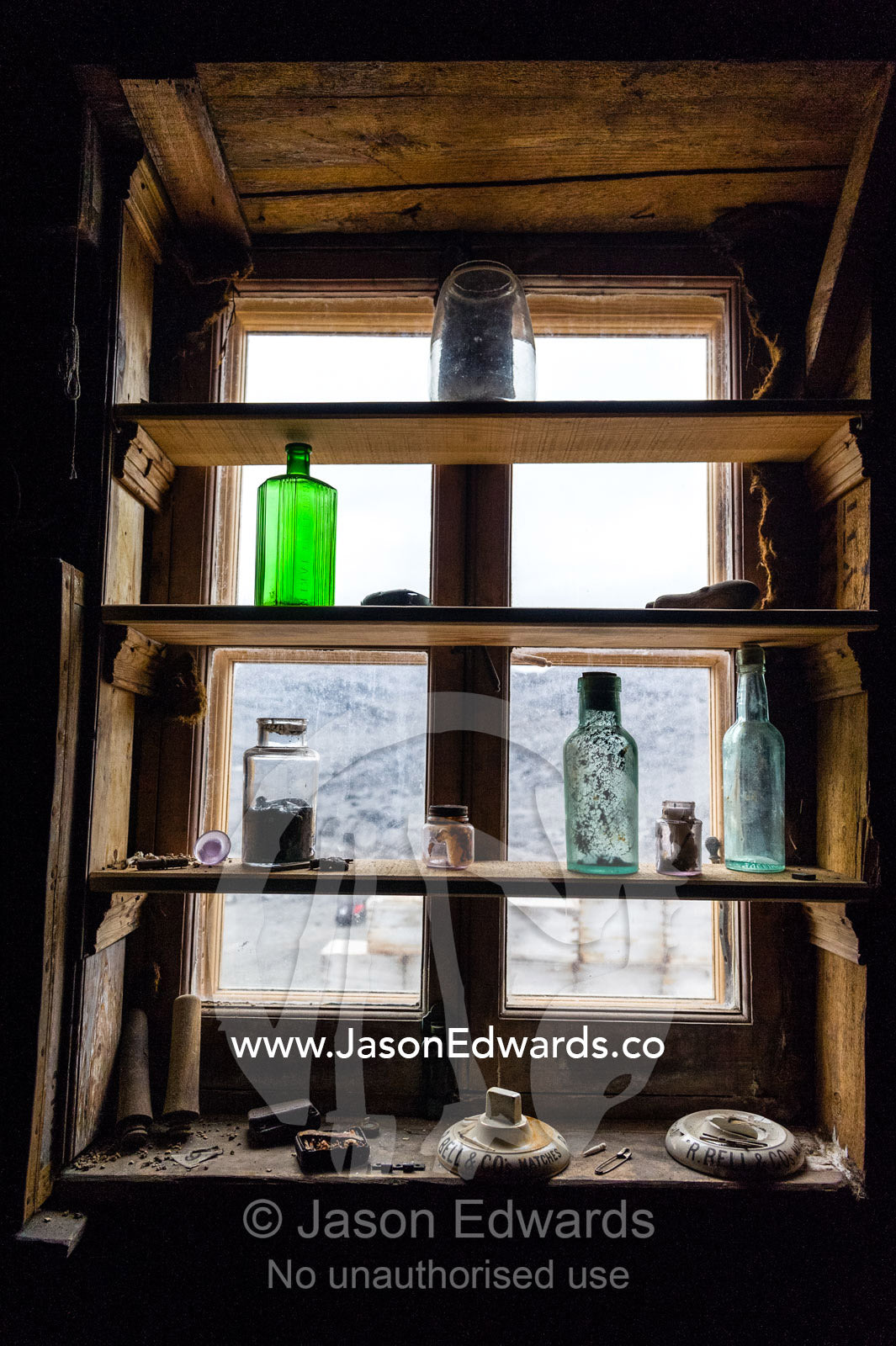 Bottles and artifacts on a windowsill bookcase in Antarctic explorer Ernest Shackleton's hut. Shackleton's Hut, Cape Royds, Ross Island, Antarctica.