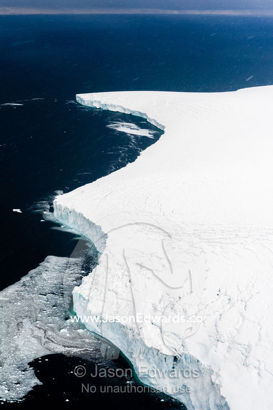 An aerial view of a glacier fracture zone falling into the ocean. Wohlschlag Bay, Ross Island, Antarctica.