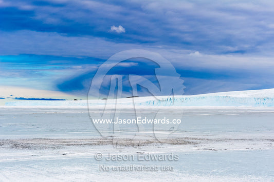 Sea ice frozen across to the base of an enormous glacier. Barne Glacier, Scott's Hut, North Bay, Cape Evans, Ross Island, Antarctica.
