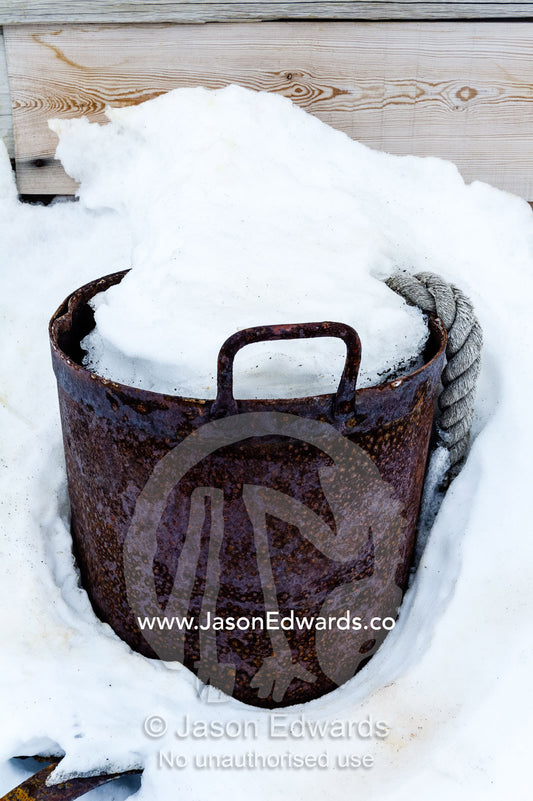 Snow fills a rusting metal drum at the Antarctic explorer Robert Falcon Scott's hut. Scott's Hut, Cape Evans, Ross Island, Antarctica.