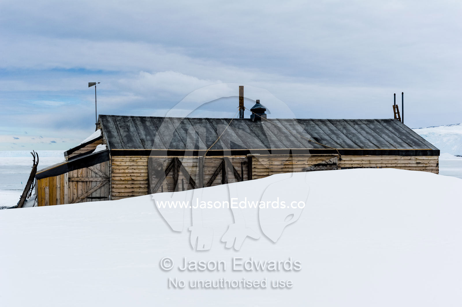 The weathered walls and window shutters of the Antarctic explorer Robert Falcon Scott's hut surrounded by snow. Scott's Hut, Cape Evans, Ross Island, Antarctica.