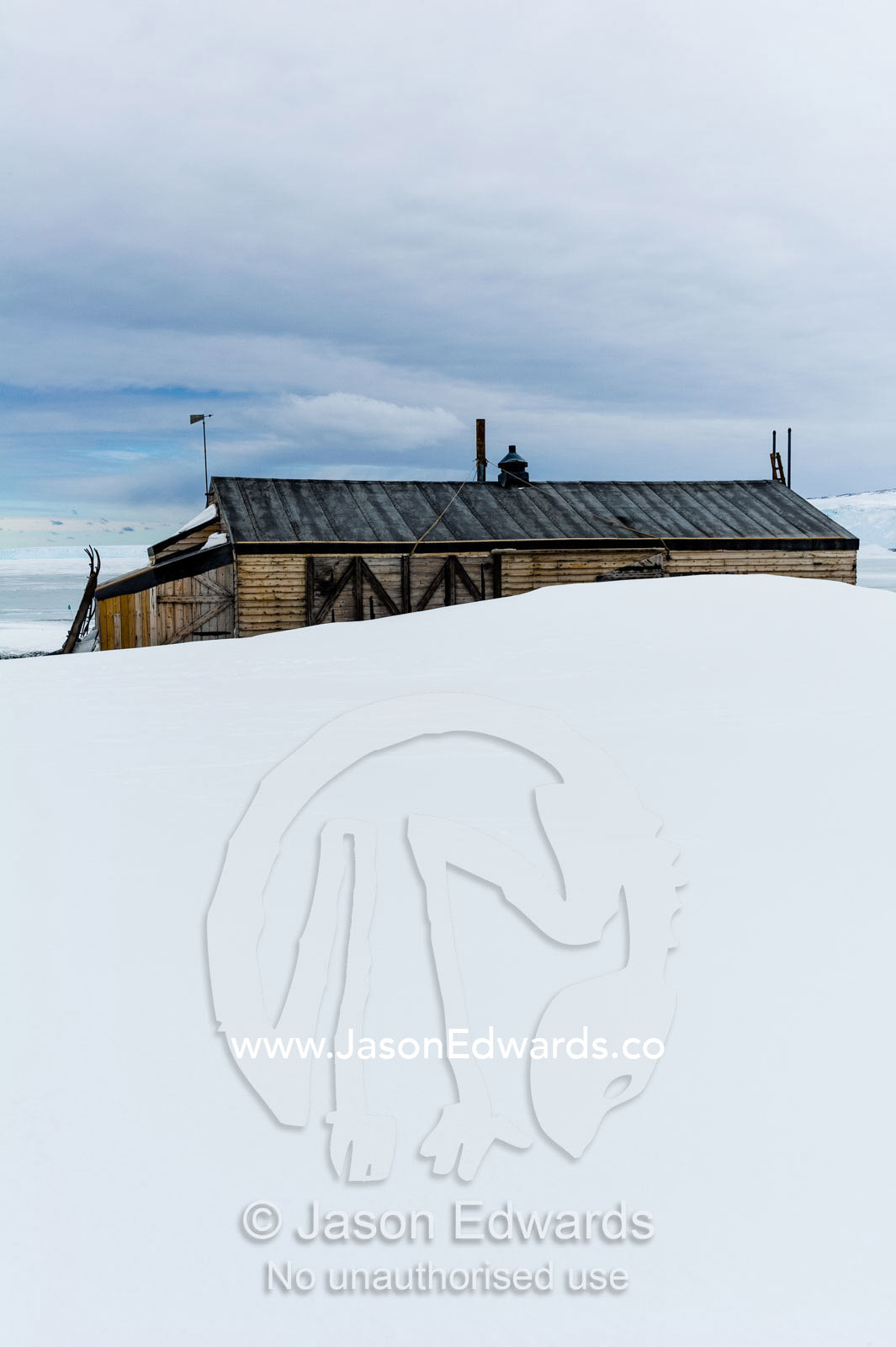 The weathered walls and window shutters of the Antarctic explorer Robert Falcon Scott's hut surrounded by snow. Scott's Hut, Cape Evans, Ross Island, Antarctica.