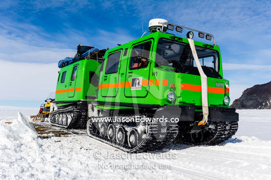 A Hagglund ice vehicle travels over a bridge on sea ice during the Antarctic summer. Erebus Bay, McMurdo Sound, Cape Evans, Ross Island Antarctica.