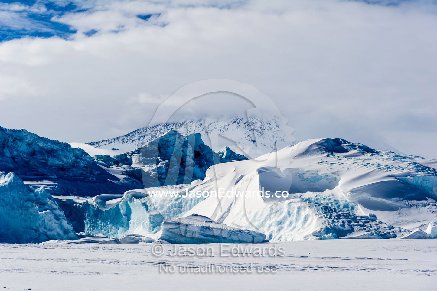 The frozen inhospitable shoreline where sea ice meets the slope of Mount Erebus. Erebus Bay, McMurdo Sound, Cape Evans, Ross Island Antarctica.