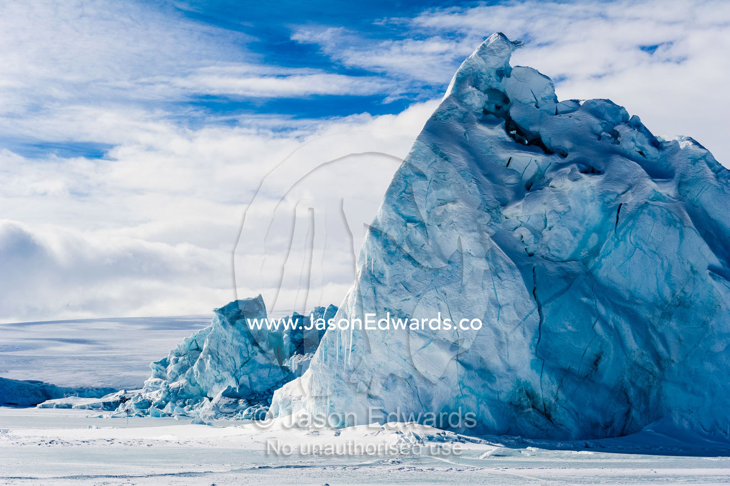 An enormous jagged iceberg trapped in frozen sea ice. Erebus Bay, McMurdo Sound, Cape Evans, Ross Island Antarctica.