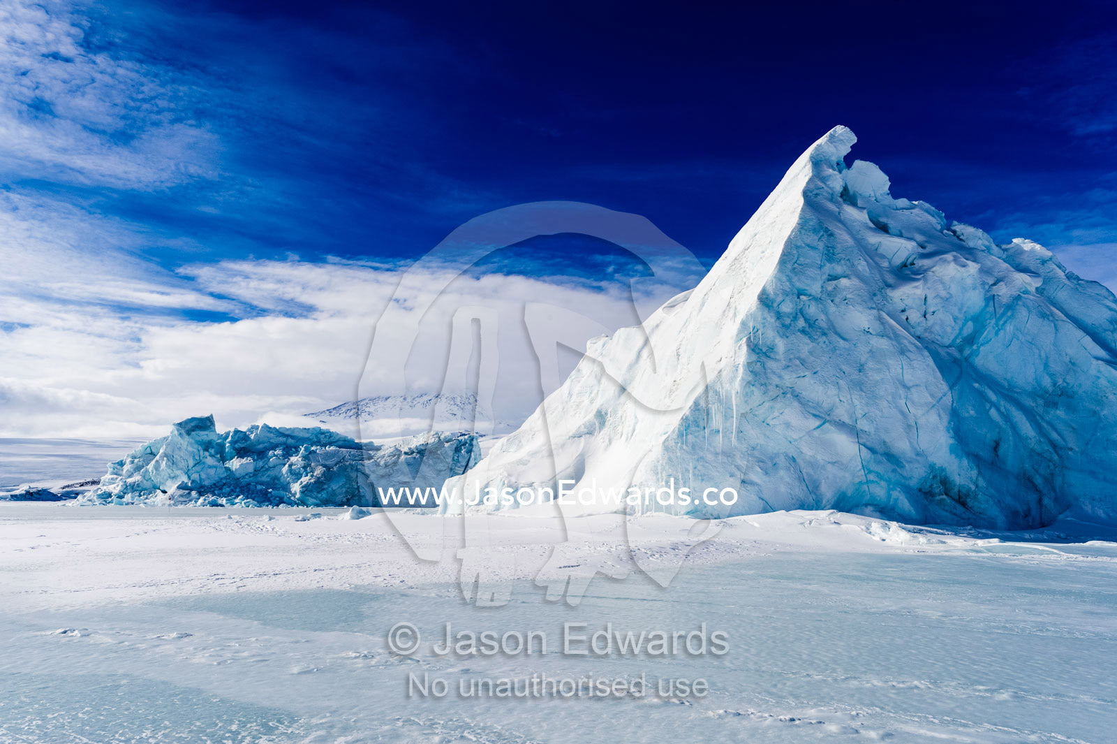 An enormous jagged iceberg trapped in frozen sea ice. Erebus Bay, McMurdo Sound, Cape Evans, Ross Island Antarctica.