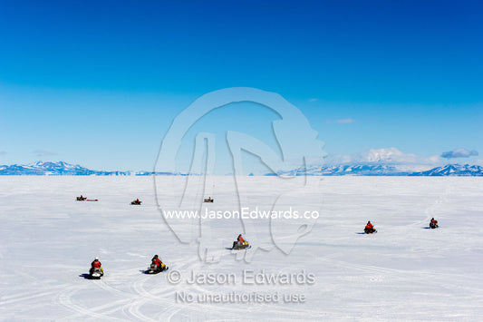 A team of skidoos crossing the frozen sea ice in Antarctica. Royal Society Range, McMurdo Sound, Ross Island, Antarctica.