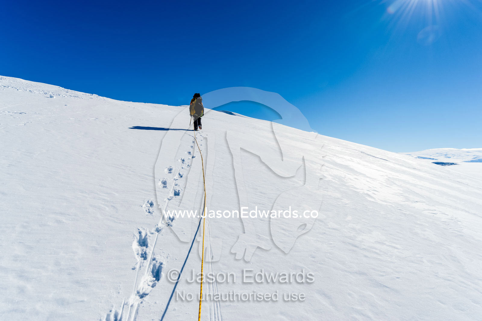 An ice guide hiking across a crevasse field on the slopes of Mount Erebus in Antarctica. Silver City Ice Fall, Hut Point Peninsula, Ross Island Antarctica.