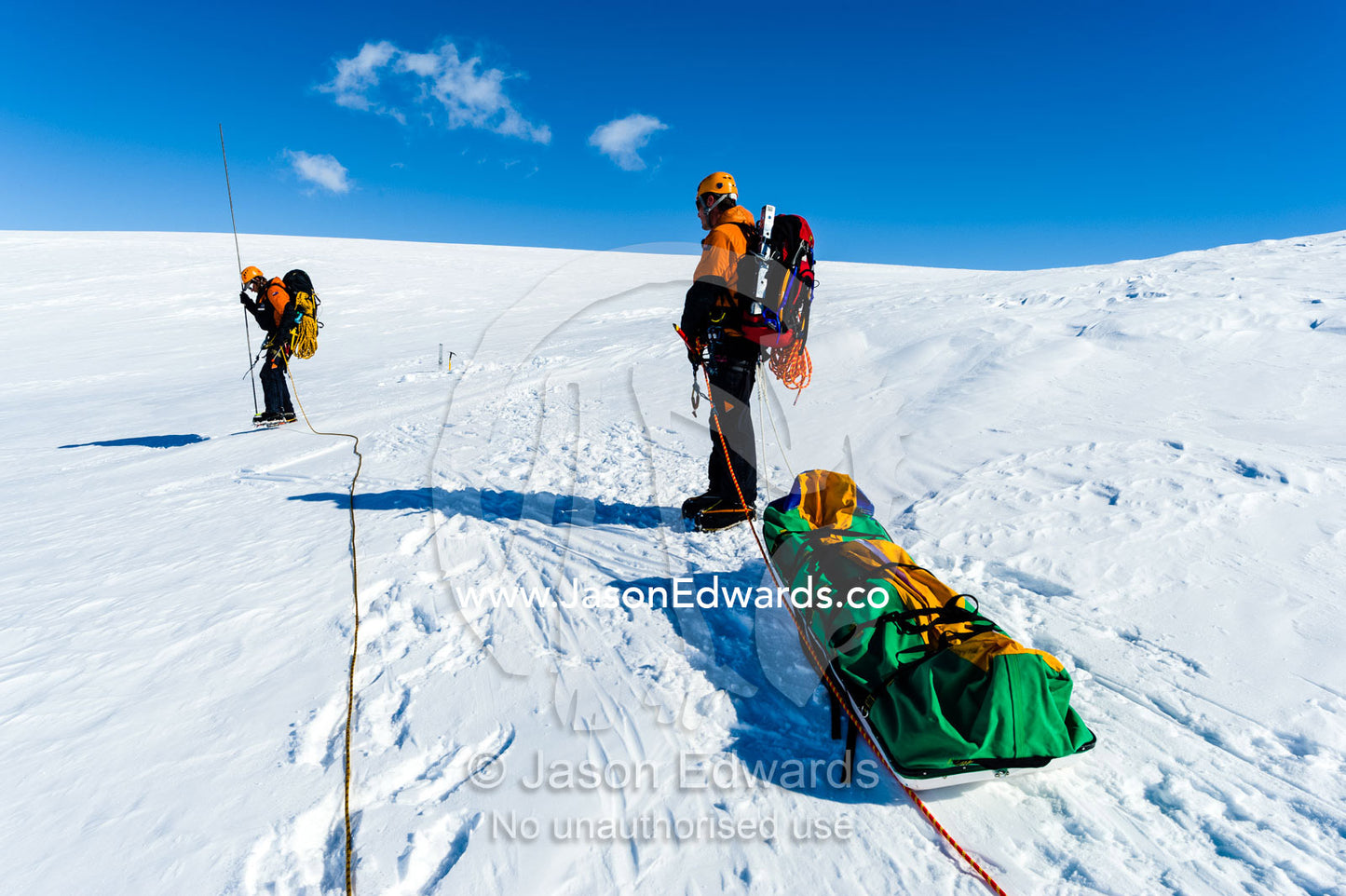 Ice guides hauling a sled as they hike across a crevasse field on the slopes of Mount Erebus in Antarctica. Silver City Ice Fall, Hut Point Peninsula, Ross Island Antarctica.