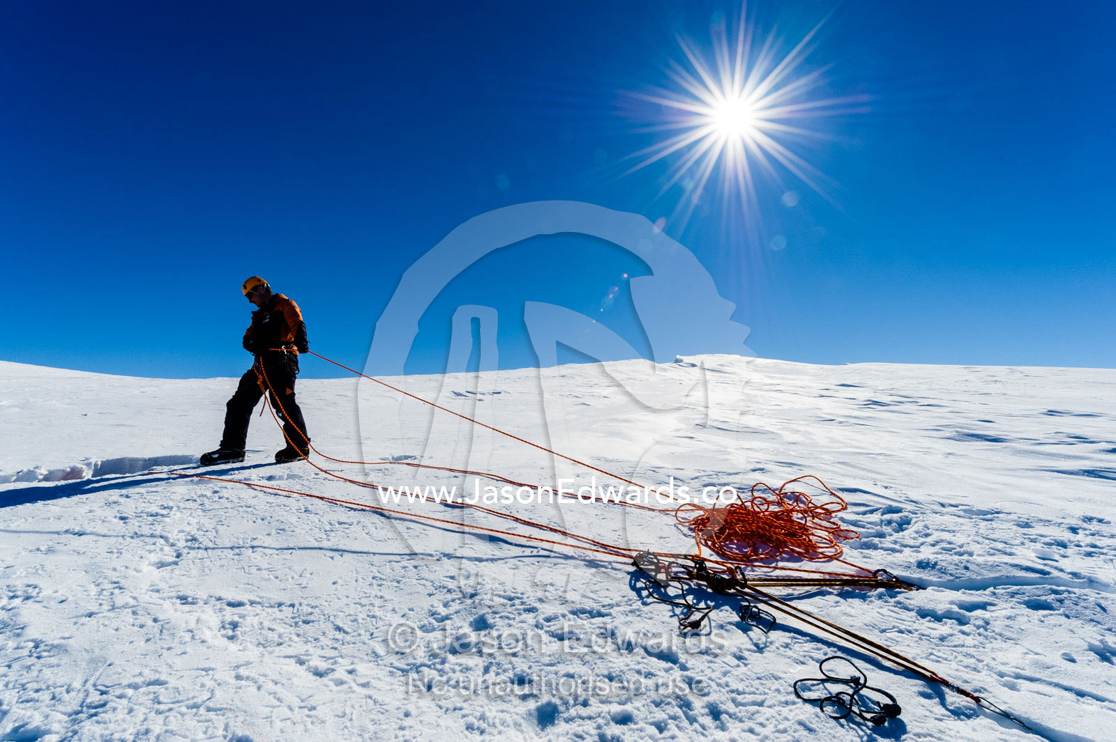 Ice guides preparing ropes to enter a crevasse on the slopes of Mount Erebus in Antarctica. Silver City Ice Fall, Hut Point Peninsula, Ross Island Antarctica.