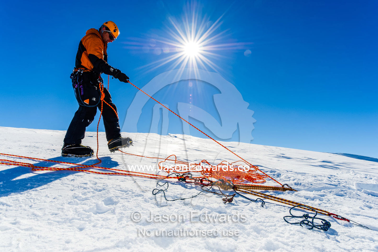 Ice guides preparing ropes to enter a crevasse on the slopes of Mount Erebus in Antarctica. Silver City Ice Fall, Hut Point Peninsula, Ross Island Antarctica.
