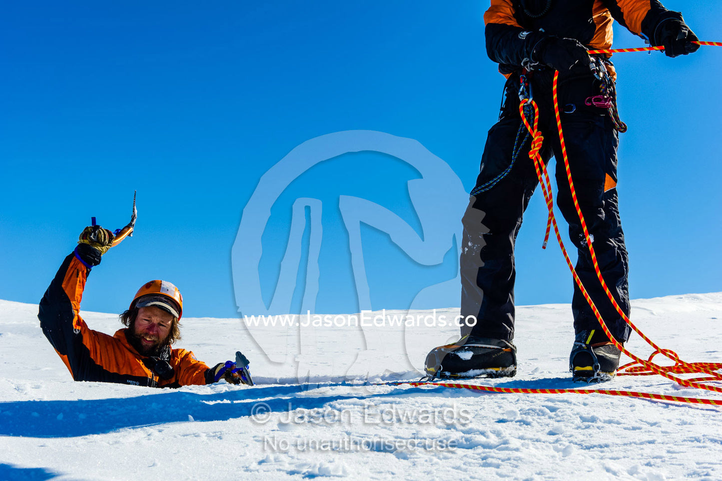 Ice guides entering a crevasse on the slopes of Mount Erebus in Antarctica. Silver City Ice Fall, Hut Point Peninsula, Ross Island Antarctica.