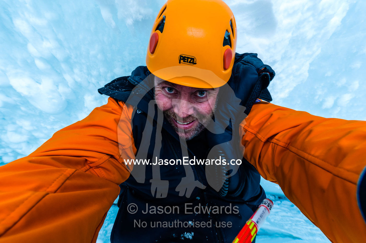 A photographer descending the sheer icy walls of a crevasse on the slopes of Mount Erebus in Antarctica. Silver City Ice Fall, Hut Point Peninsula, Ross Island Antarctica.